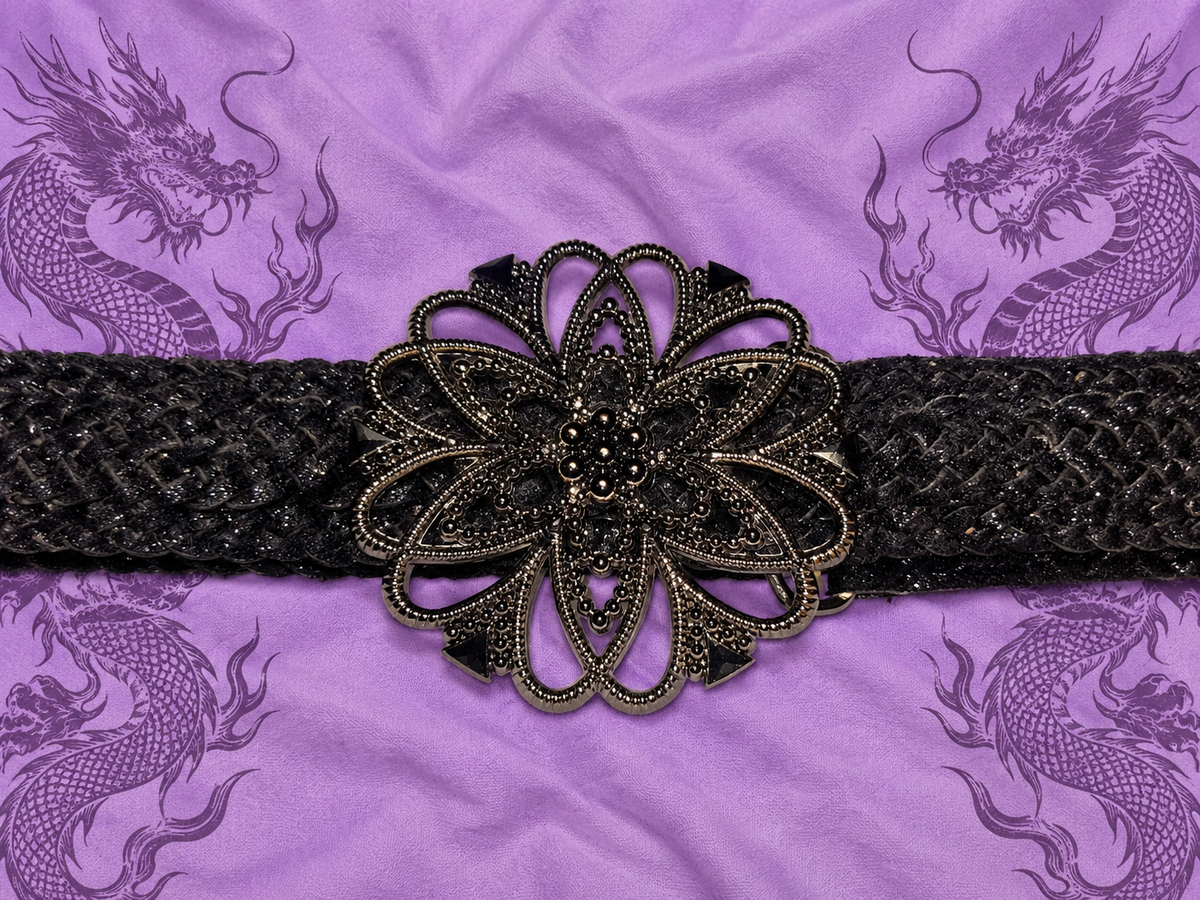 Cintura nera intrecciata con maxi fibbia floreale

Un accessorio dal carattere deciso, perfetto per completare outfit Y2K, gothic, boho e alternative.

Questa particolare cintura presenta una lavorazione intrecciata nera e una grande fibbia decorativa a f