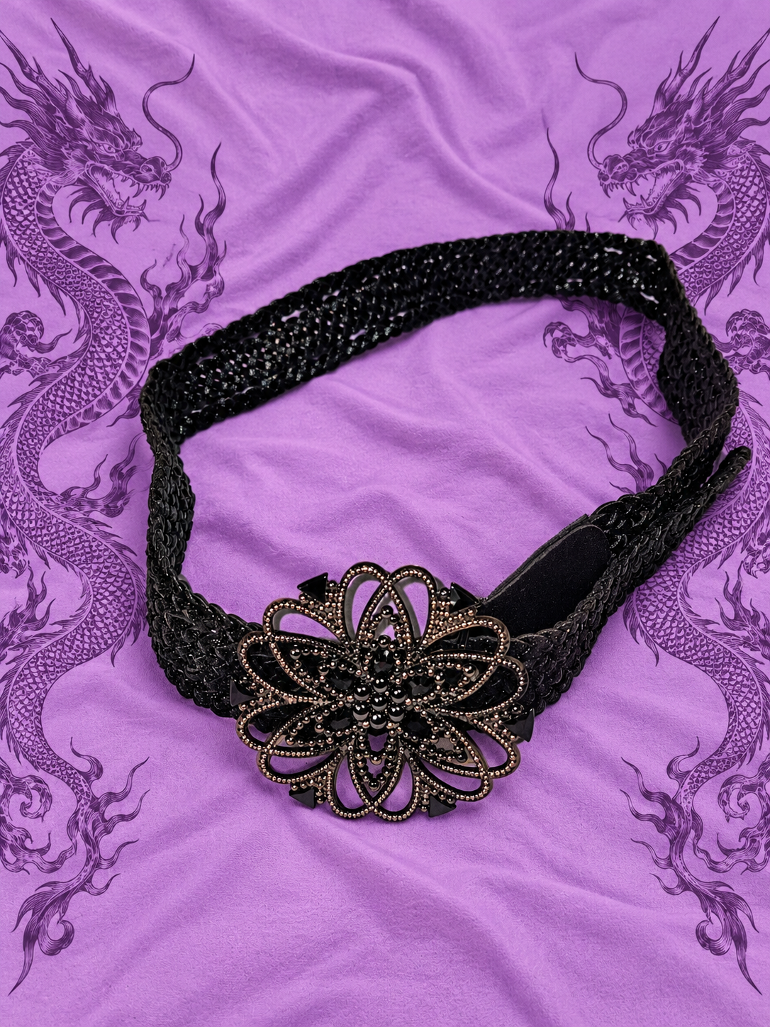 Cintura nera intrecciata con maxi fibbia floreale

Un accessorio dal carattere deciso, perfetto per completare outfit Y2K, gothic, boho e alternative.

Questa particolare cintura presenta una lavorazione intrecciata nera e una grande fibbia decorativa a f